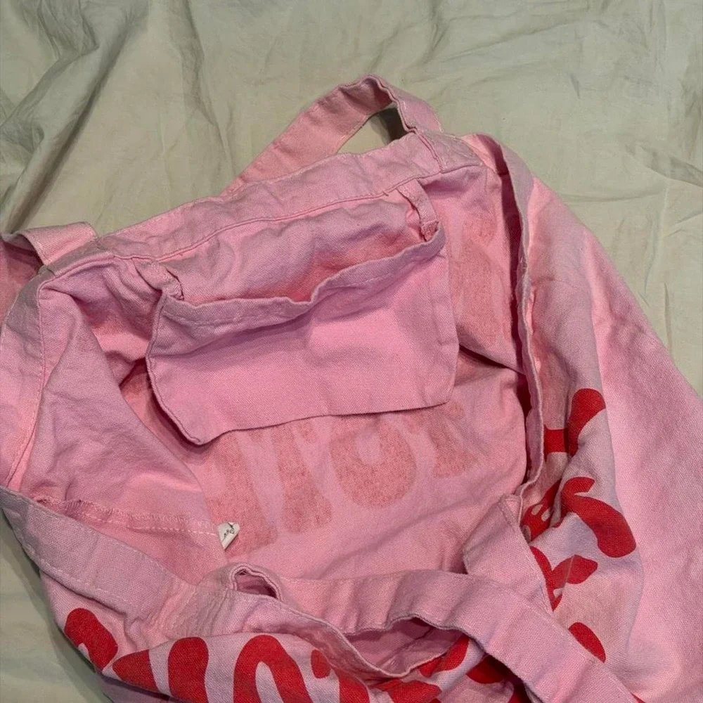 Pink tote bag with red text